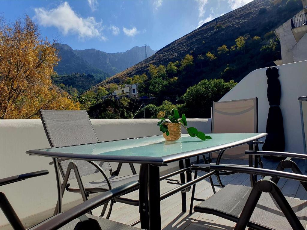 a table on a balcony with a view of a mountain at Esencia Cazorla in Cazorla
