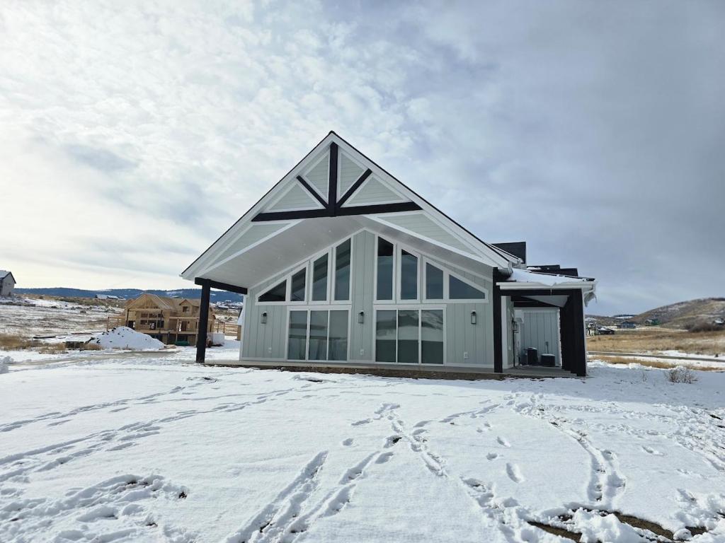 a house in the snow with footprints in the snow at Sky Sapphire Haven in Fish Haven
