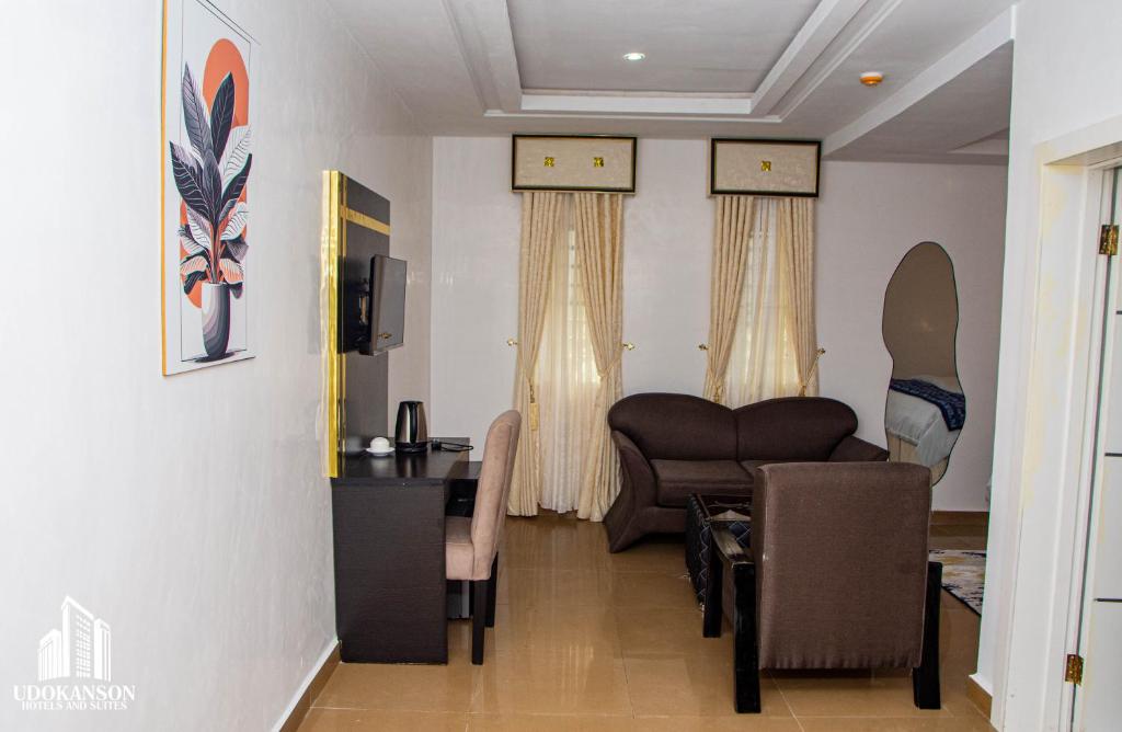 a living room with a couch and a table and chairs at Udokanson Hotel And Suites in Agbor