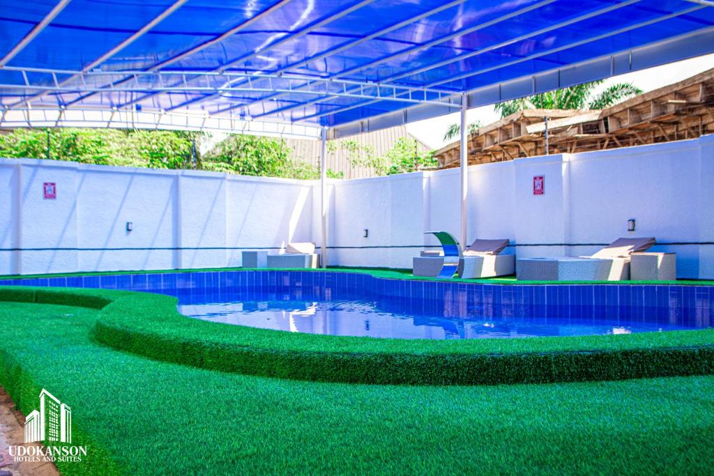 a large swimming pool with green artificial grass at Udokanson Hotel And Suites in Agbor