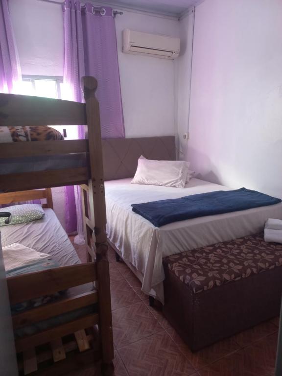 a bedroom with two bunk beds and a chair at Casa Familiar Da Nise in São Gabriel