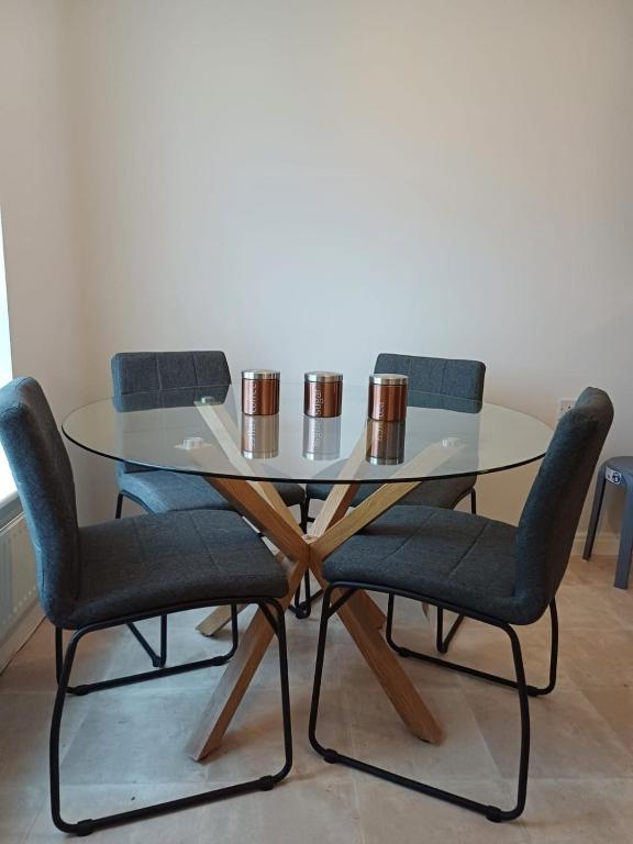 Hotel Great Home, a glass table with two chairs and two cups on it at Great Home in Liverpool