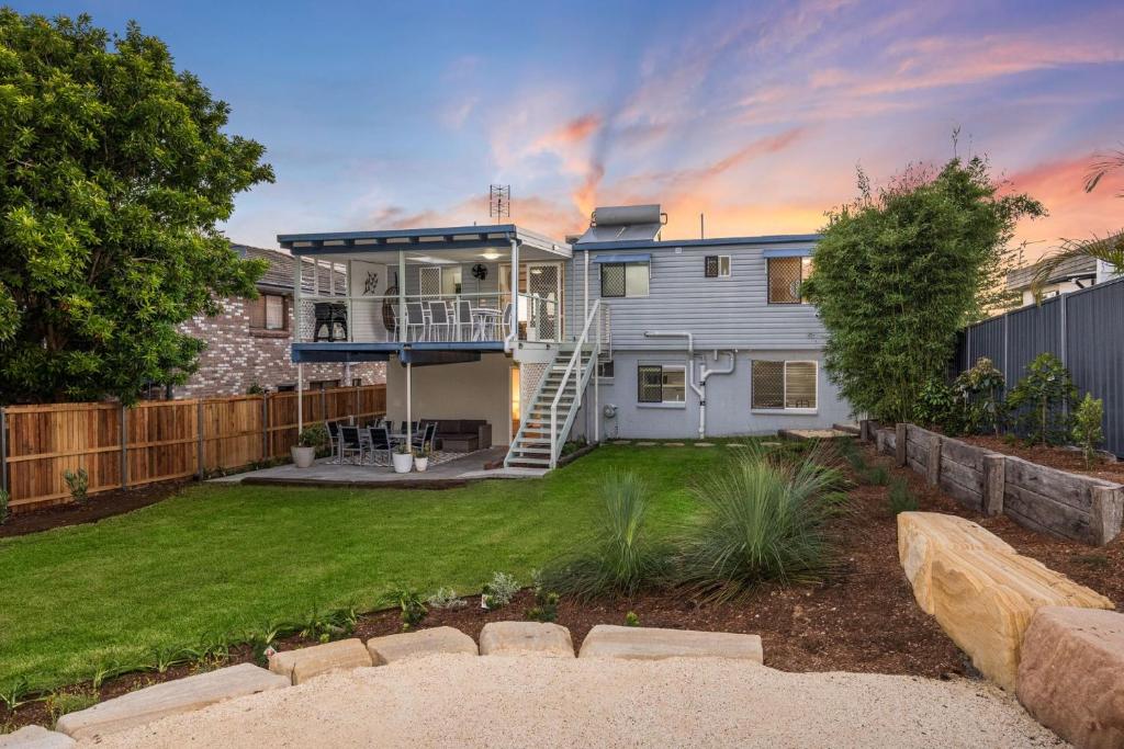 a house with a deck and a yard at Kaimai House in South West Rocks