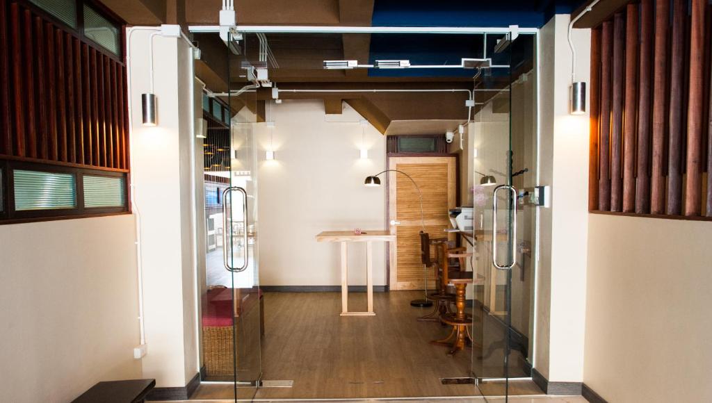 a hallway with a glass door leading into a room at KENCOZY accommodation in Bangkok