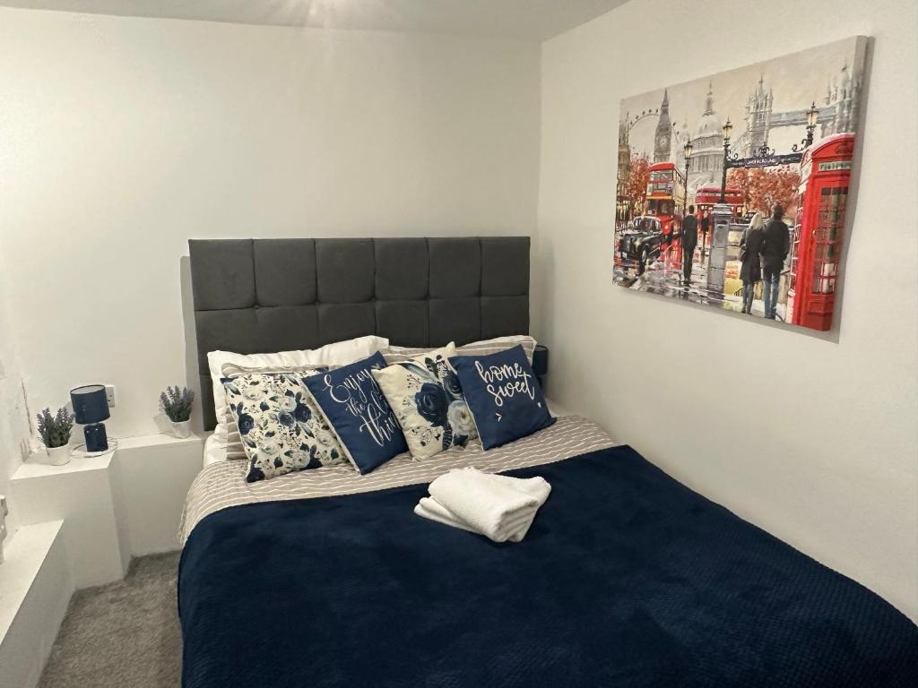 une chambre avec un grand lit avec des draps et des oreillers bleus dans l'établissement Mornington Crescent Suites, à Londres