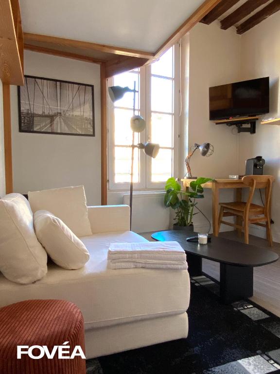 un salon avec un canapé blanc et une table dans l'établissement Ares, à Caen