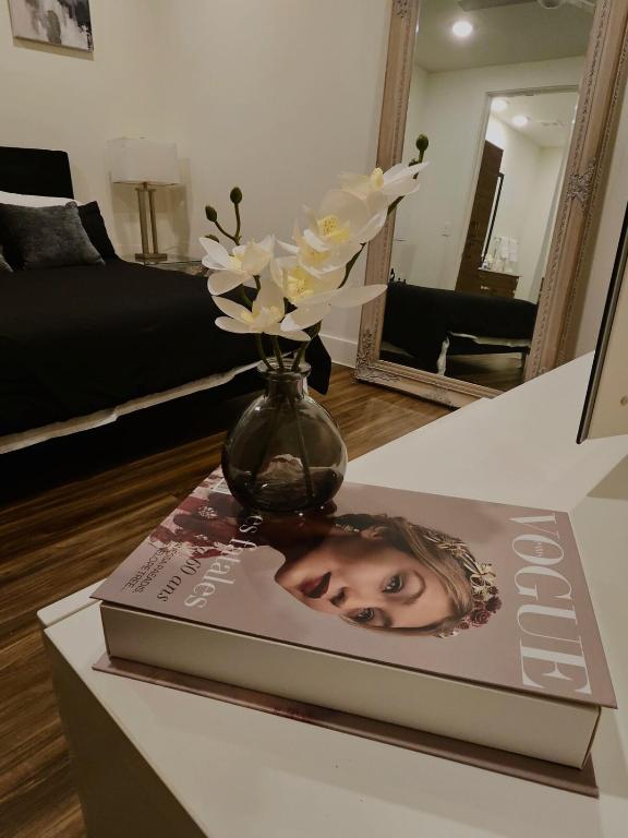 Eine Vase mit Blumen auf einem Buch in der Unterkunft lavish apartment downtown in Houston