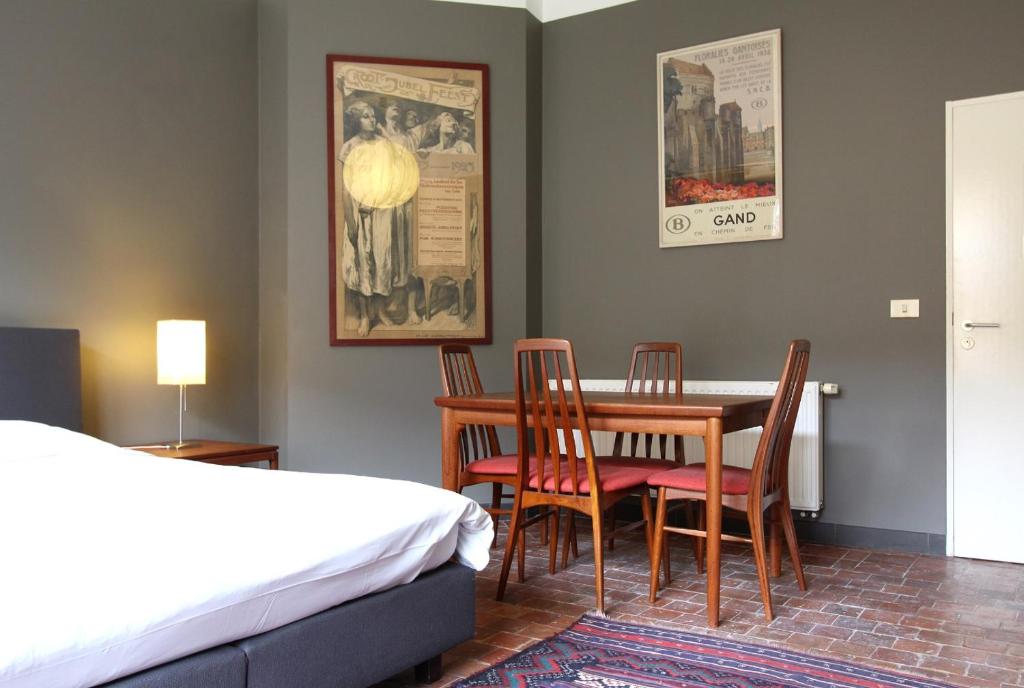 Schlafzimmer mit einem Bett, einem Tisch und Stühlen in der Unterkunft Baeten's bed and breakfast in Gent