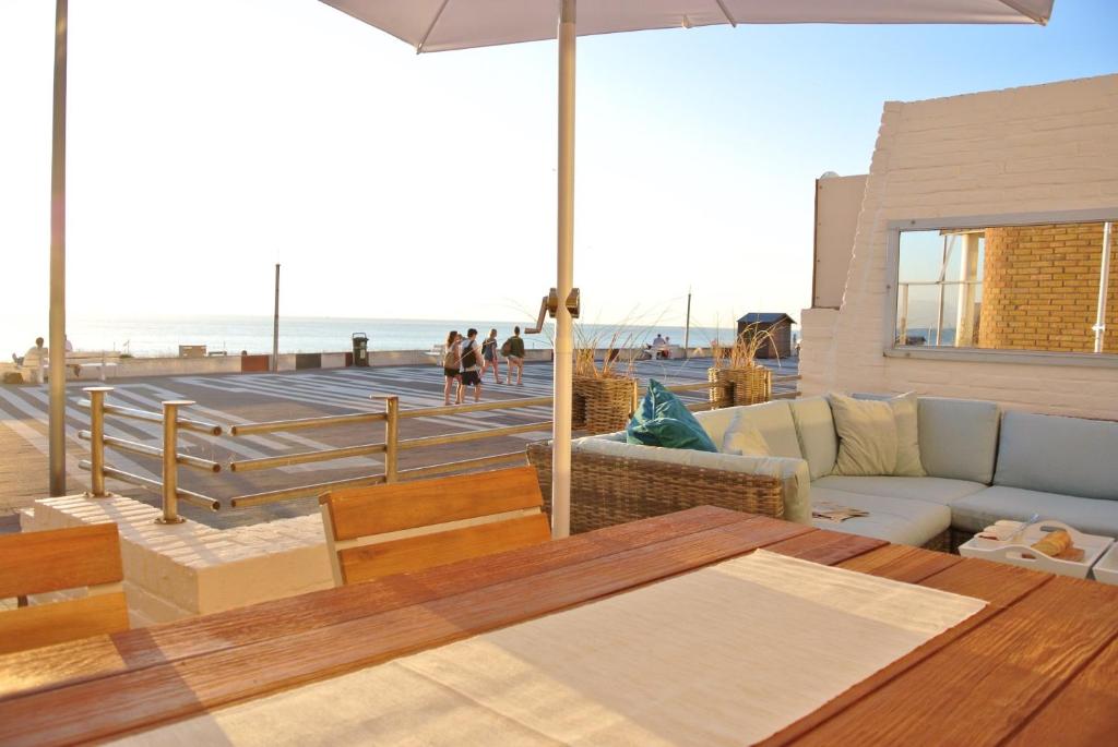 ein Wohnzimmer mit einem Tisch und Strandblick in der Unterkunft Strandzicht Zandvoort in Zandvoort