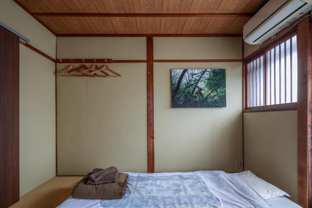 a bedroom with a bed and a window at Yadoya Hiraiwa private ryokan in Kyoto