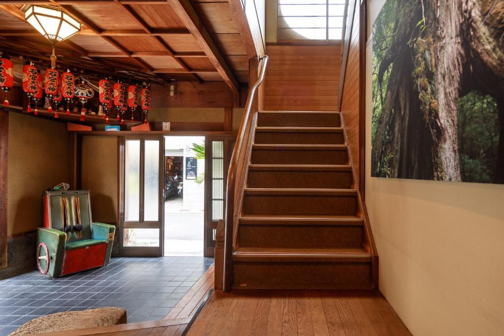a staircase in a room with a painting on the wall at Yadoya Hiraiwa private ryokan in Kyoto