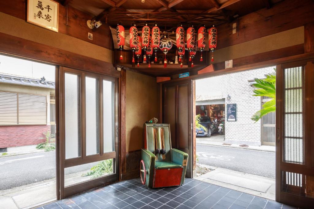 a room with a chair in front of a building at Yadoya Hiraiwa private ryokan in Kyoto