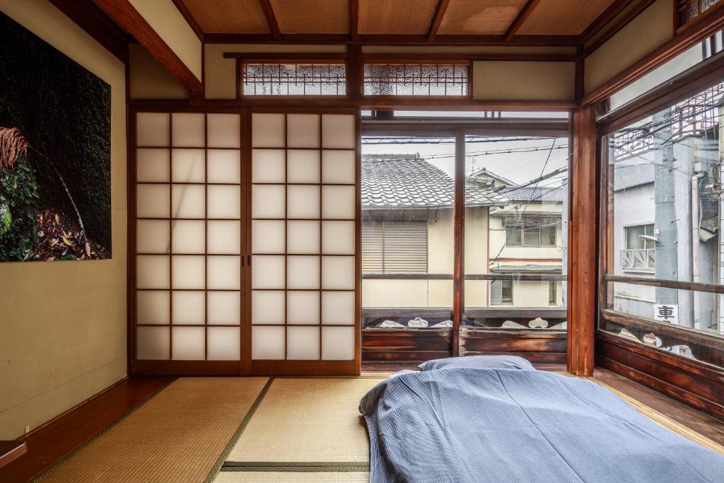a room with a bed and a large window at Yadoya Hiraiwa private ryokan in Kyoto