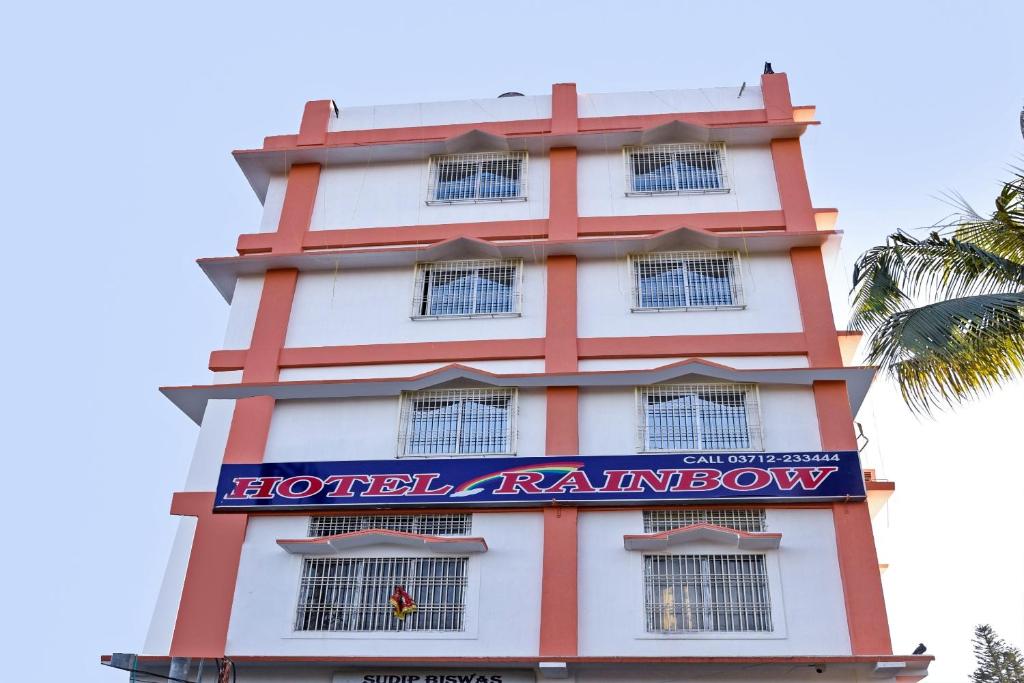 Un edificio rojo y blanco con un cartel. en Hotel O Rainbow, en Tezpur
