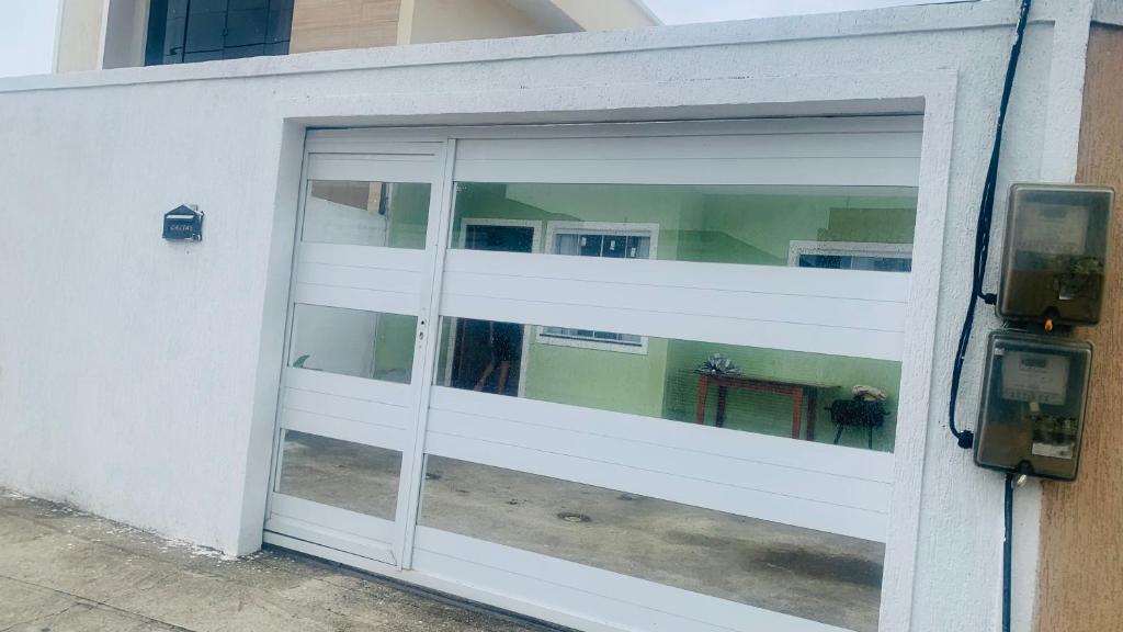 a sliding glass door with a table inside of it at Casa pra temporada 3 quartos 10 km de Cabo frio in São Pedro da Aldeia