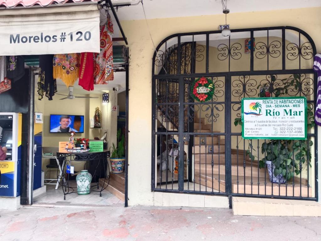 a store front with an iron gate with a sign on it at hotel rio mar in Puerto Vallarta