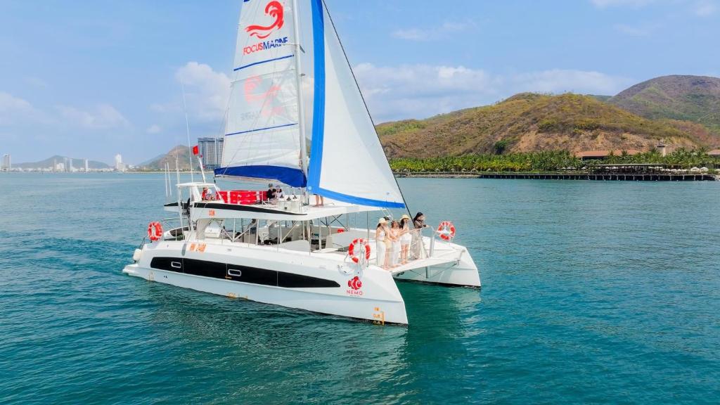 un grupo de personas en un velero en el agua en Sunrise Catamaran Yacht Tour, en Nha Trang