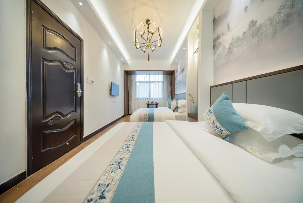 凤凰FenghuangQixin Guesthouse的卧室配有一张白色的大床和一扇门