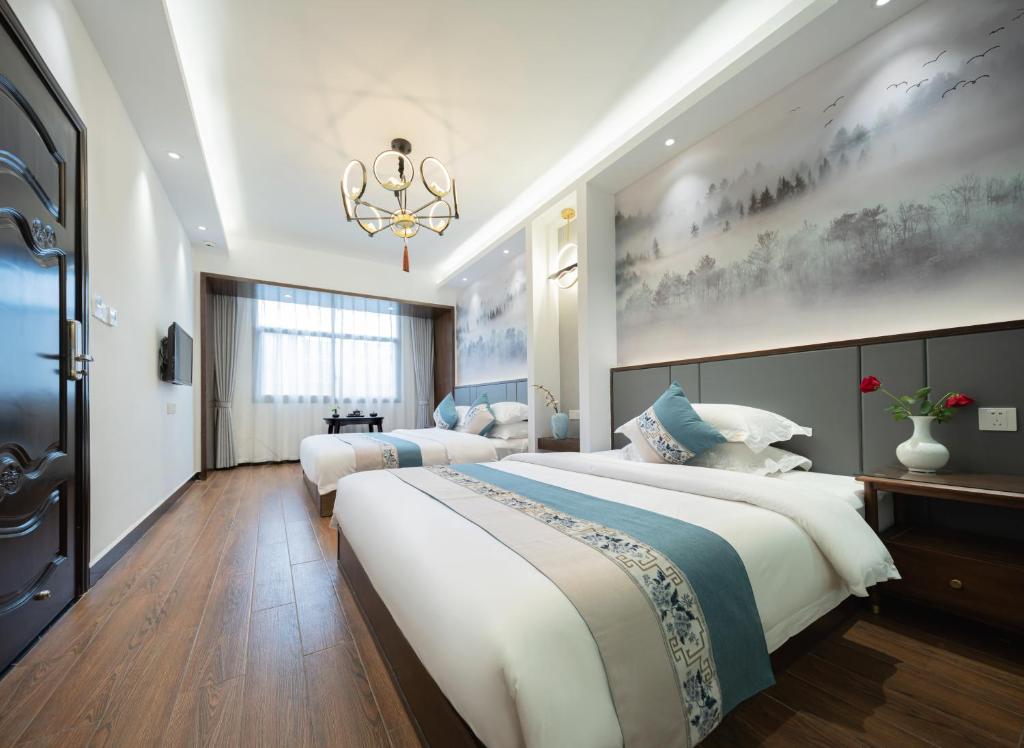 凤凰FenghuangQixin Guesthouse的一间卧室配有两张床和吊灯。