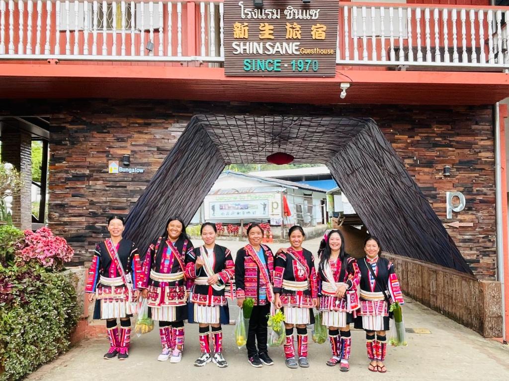 a group of women standing in front of a bridge at Shin Sane Guest House in Mae Salong