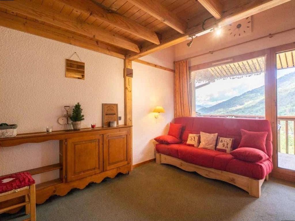 ein Wohnzimmer mit einem roten Sofa und einem Fenster in der Unterkunft Studio alpin mezzanine, 4 pers, animaux acceptés, parking en option - FR-1-291-1022 in Valmorel