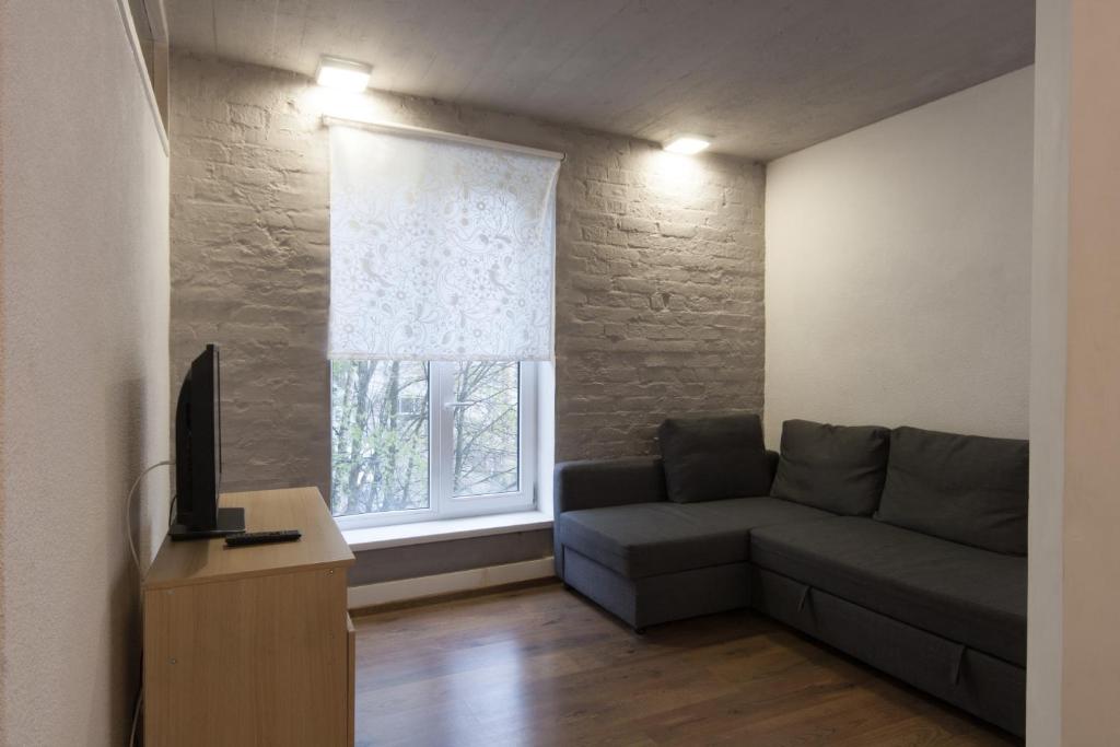 uma sala de estar com um sofá e uma janela em Apartments Vyborg em Vyborg
