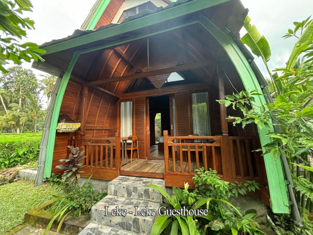 a small house with a porch and a deck at Ubud Leke-Leke Guesthouse - Rumah Kayu in Gianyar