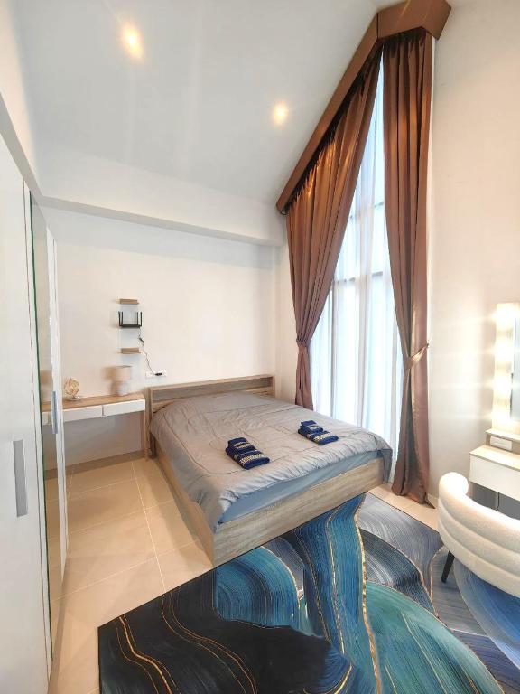 a bedroom with a bed and a large window at Family house Aiyada in Phuket