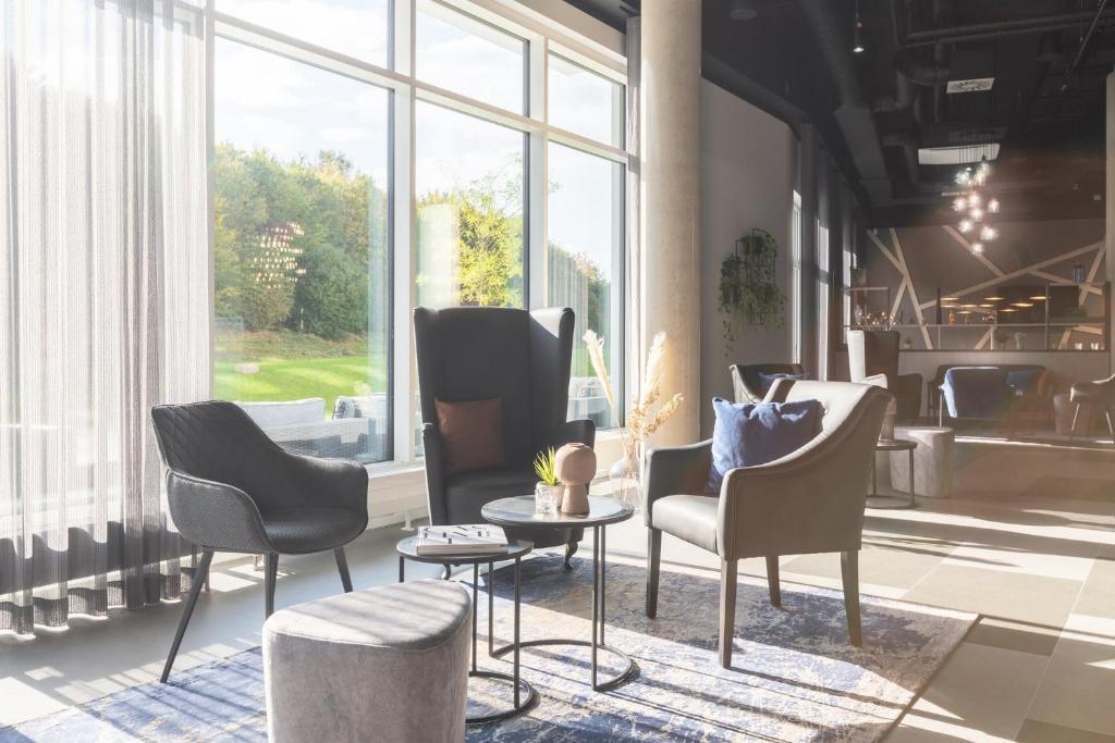 アウクスブルクにあるCandlewood Suites Augsburg by IHGのロビー(椅子、テーブル付)、大きな窓