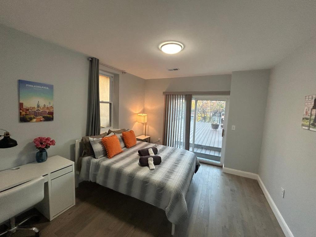 una camera da letto con un letto con cuscini arancioni e una finestra di Cozy 2-3 Bedroom Apartment in Center City! a Philadelphia
