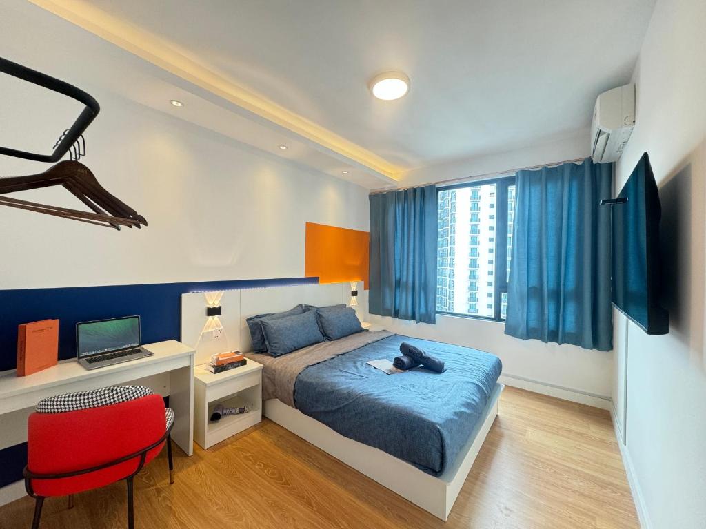 a bedroom with a bed and a desk with a laptop at X - The Subiaco - Edumetro Subang Jaya in Subang Jaya