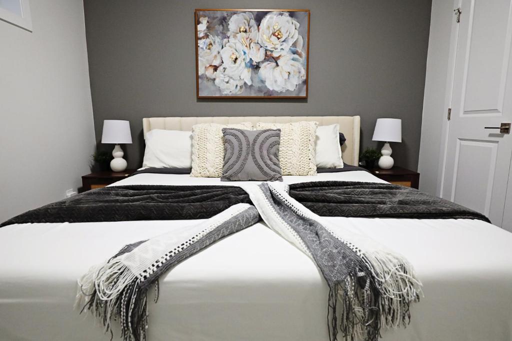 ein Schlafzimmer mit einem großen Bett mit einer Decke in der Unterkunft Beautiful Suite King Bed,Long Stays,Disney,Airport in Edmonton