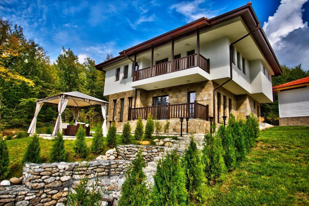 a house with a stone wall in front of it at Villa Eta in Apriltsi