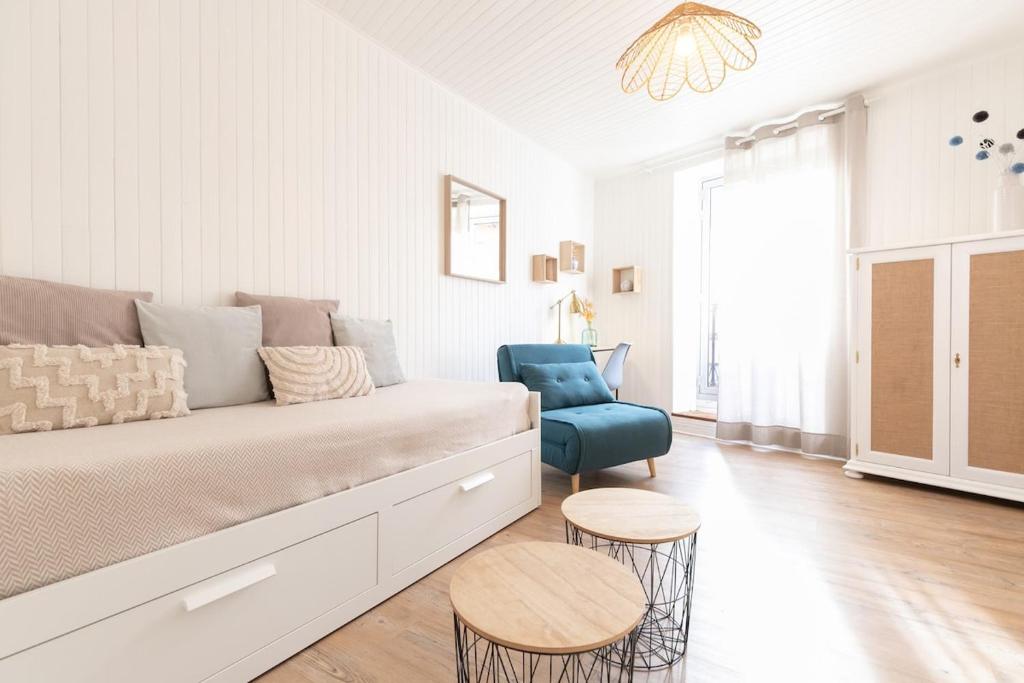 a white living room with a couch and a chair at Au Petit Sommet - OursBlanc APPARTEMENT CENTRE VILLE 30m2 in Modane
