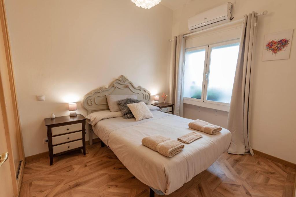 Hotel El Chaflán de Vallecas, a bedroom with a bed with two towels on it at El Chaflán de Vallecas in Madrid