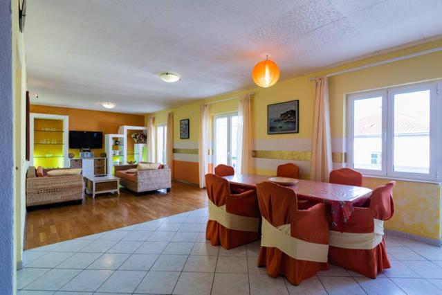 a living room with a table and chairs in it at Pia Apartment in Dugi Rat