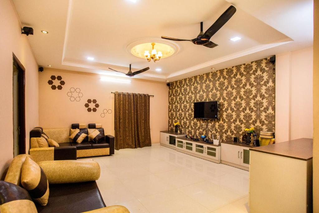 a living room with a couch and a tv at HEAVEN PLEASANT STAy in Chennai