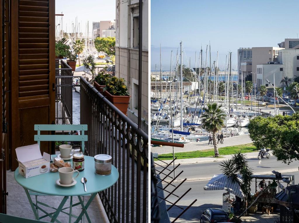a table on a balcony with a view of a marina at Cassari UpArtments in Palermo
