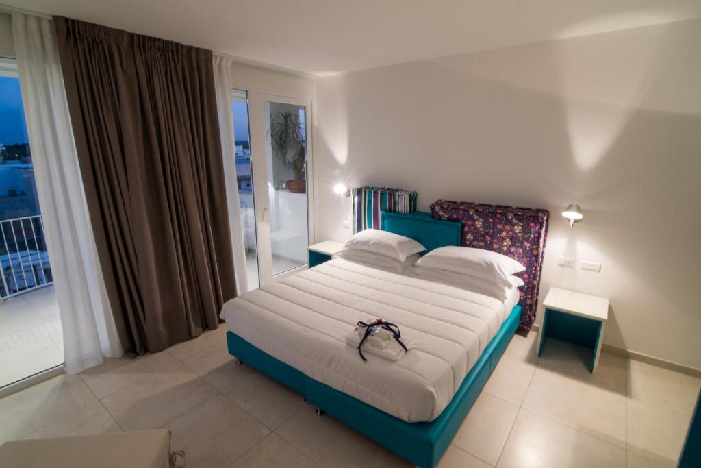 a bedroom with a large bed and a balcony at Hotel Cicò in Torre Santa Sabina