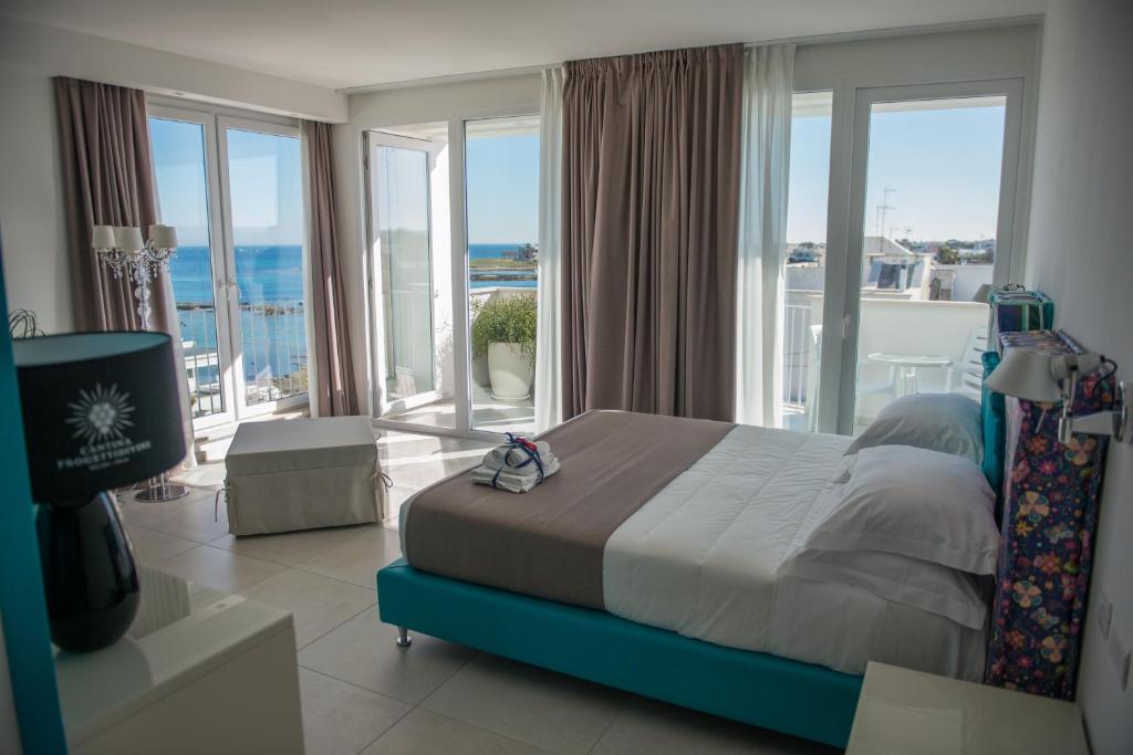 a bedroom with a bed with a view of the ocean at Hotel Cicò in Torre Santa Sabina