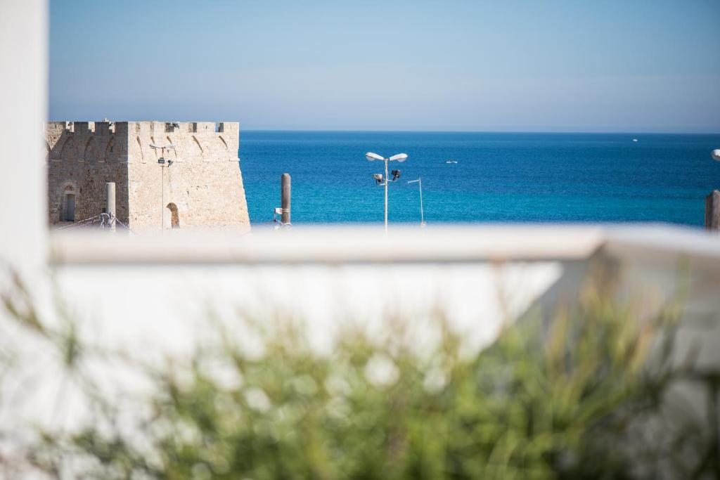 a view of a castle and the ocean from a balcony at Hotel Cicò in Torre Santa Sabina