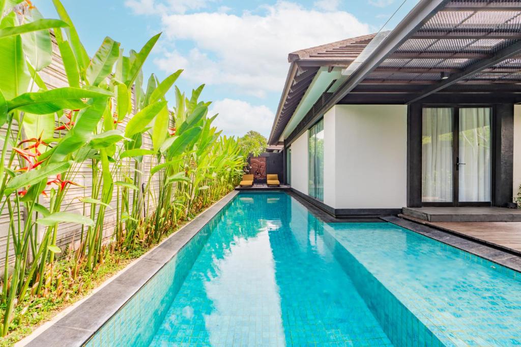 ein Swimmingpool vor einer Villa in der Unterkunft Javana Royal Villas in Seminyak