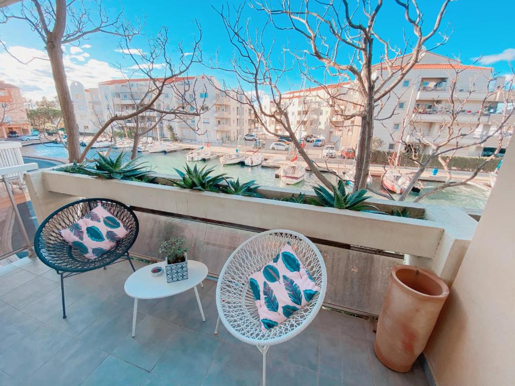 d'un balcon avec deux chaises, une table et une fenêtre. dans l'établissement Superbe T2 au calme avec balcon sur la marina - 10, à Canet