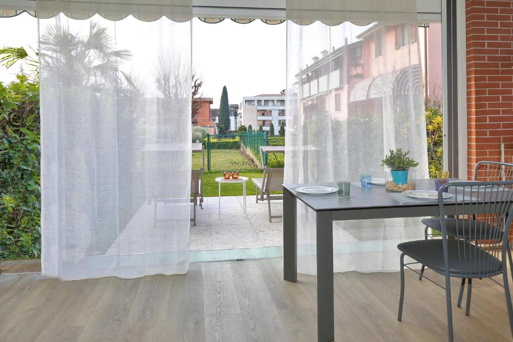 a table and chairs in front of a window at Appartamento San Zeno in Bardolino