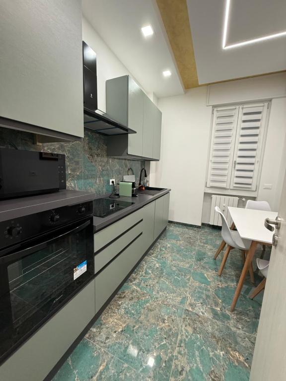 a kitchen with white cabinets and a table in it at Relax assoluto in Cremona
