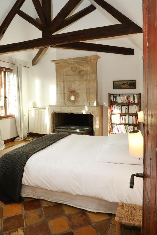 - une chambre avec un grand lit blanc et une cheminée dans l'établissement Made in Normandie by La boite en Plus, à Villers-Saint-Frambourg