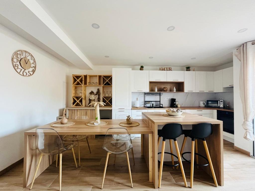 une cuisine avec une table et des chaises en bois dans l'établissement L effet mer, à Ajaccio
