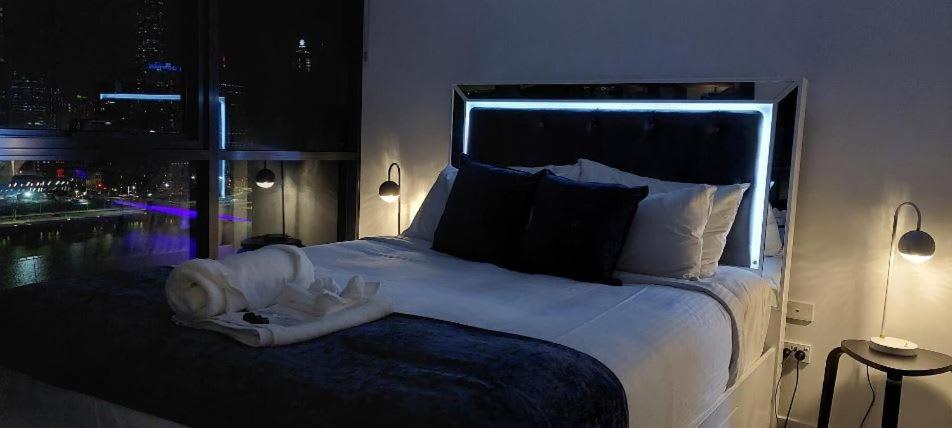 Un dormitorio con una gran cama blanca con ventana. en 2BR Apartment in South Brisbane with Spectacular River View, en Brisbane