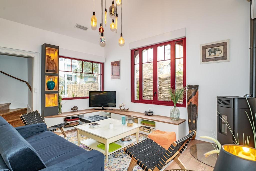 un salon avec un canapé bleu et une table dans l'établissement Arcachon maison 2e ligne accès privé plage 50m, à Arcachon