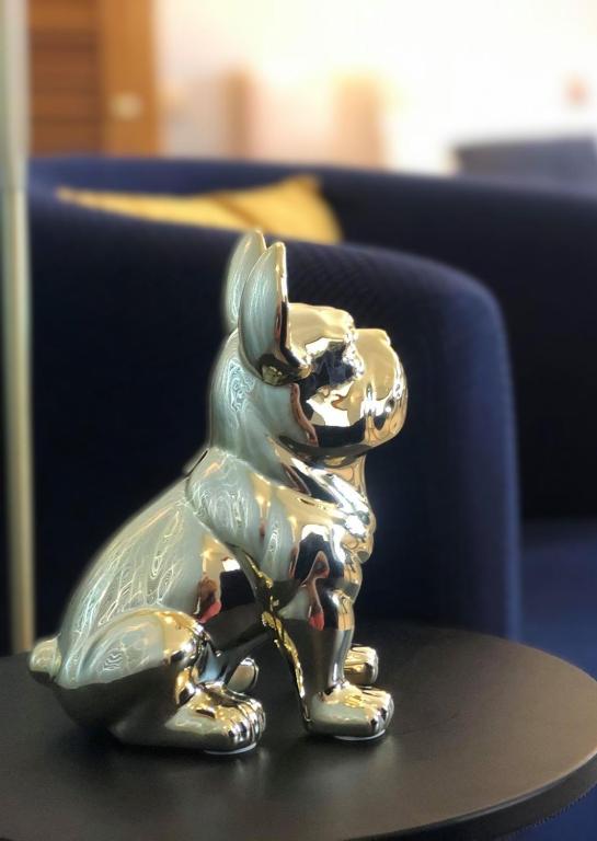 une figurine argentée d'un chien sur une table dans l'établissement Le Clos de la Barre- Chambres d'hôtes de charme en Normandie-BASLY-Proche plage débarquement, à Basly